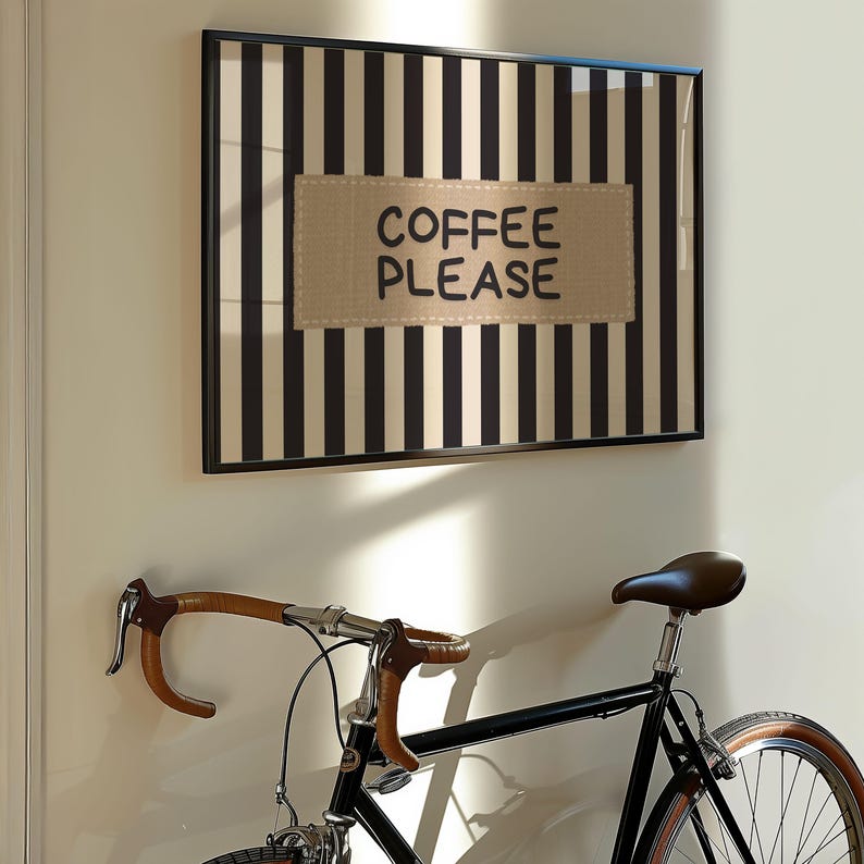 Puede incluir: Una taza de cer&aacute;mica blanca con asa negra y el texto "But First, Coffee" en negrita negra. La taza se encuentra sobre un fondo borroso, sugiriendo un ambiente acogedor.