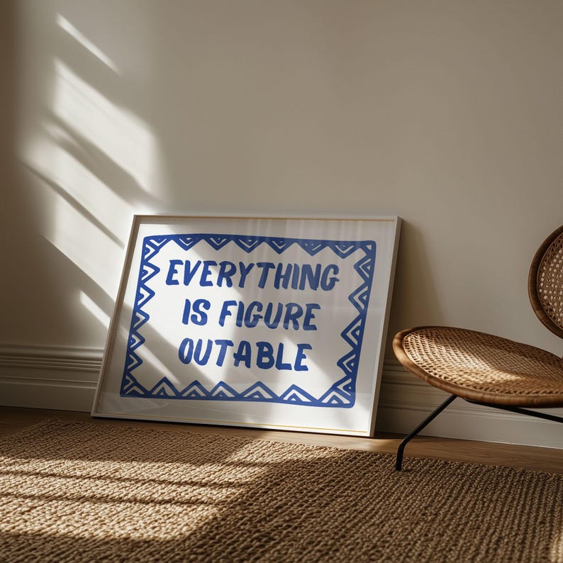 May include: A white framed print with a blue border and the text "EVERYTHING IS FIGURE OUTABLE" in blue lettering.