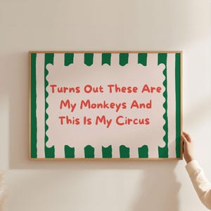 Könnte beinhalten: Ein gerahmter Druck mit grünem und weißem gestreiftem Hintergrund. Der Druck zeigt ein rosa Rechteck mit dem Text "Turns Out These Are My Monkeys And This Is My Circus" in rot.