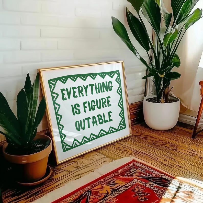 Pu&ograve; includere: Una stampa incorniciata con la scritta "EVERYTHING IS FIGURE OUTABLE" in lettere verdi. La cornice &egrave; dorata e la stampa &egrave; appoggiata a un muro di mattoni bianchi. Sono visibili anche piante in vaso e un tappeto fantasia.