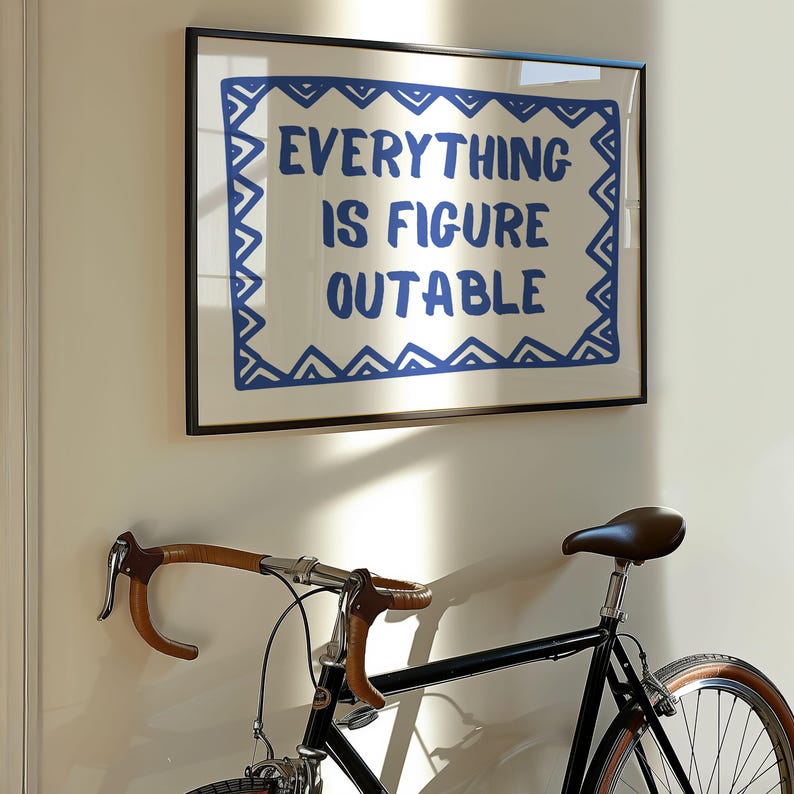 May include: A framed print with a white background and a blue border. The print features the text "EVERYTHING IS FIGURE OUTABLE" in blue lettering.