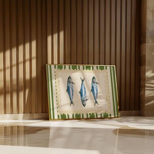 May include: A framed print with a green and white striped border. The print features three blue fish with white bellies, arranged in a row. The fish are on a white background with a vintage look.