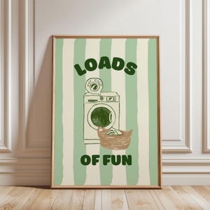 May include: A green and white striped poster with the text "LOADS OF FUN" and a cartoon illustration of a washing machine with a basket of laundry.