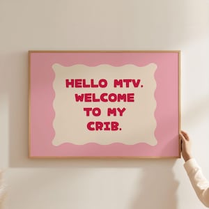 Peut inclure: Une affiche encadrée rose et beige avec le texte "HELLO MTV. WELCOME TO MY CRIB." en rouge. L'œuvre d'art a une bordure rose clair et un centre beige en forme de nuage. Le cadre est de couleur marron clair.
