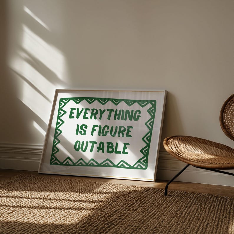 Pu&ograve; includere: Una stampa incorniciata con la scritta "EVERYTHING IS FIGURE OUTABLE" in verde su sfondo bianco. La stampa ha un bordo verde ed &egrave; appoggiata a un muro. Sullo sfondo c'&egrave; una sedia in vimini.