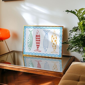 May include: A framed print of four colorful fish with wavy lines around the border. The fish are blue, green, red, and yellow with white outlines.