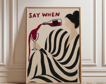 May include: A framed art print featuring a woman pouring wine into a glass. The artwork has a beige background with a black and white striped pattern. The text "SAY WHEN" is in red at the top.