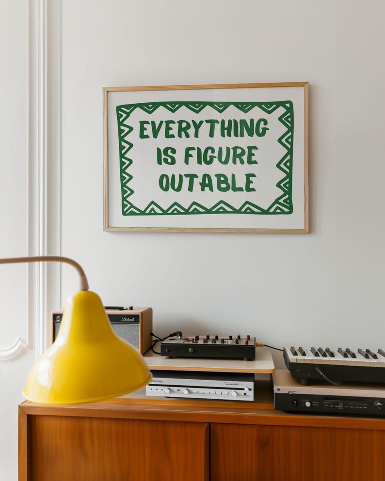 Pu&ograve; includere: Una stampa incorniciata con la scritta "EVERYTHING IS FIGURE OUTABLE" in verde su sfondo bianco. La stampa &egrave; appesa sopra un mobile in legno con una lampada gialla, un piccolo amplificatore e apparecchiature musicali elettroniche.
