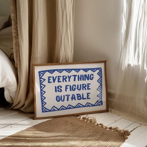 May include: A framed print with a white background and blue text that reads "EVERYTHING IS FIGURE OUTABLE" in a decorative font. The frame is made of natural woven material.