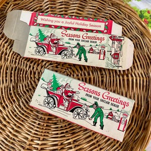 May include: Vintage holiday card boxes with a red and white design. The boxes feature Santa Claus in a red car, a green-clad person, and the text "Seasons Greetings From Your Sinclair Dealer."
