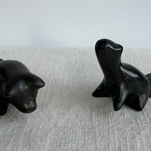 May include: Two small black ceramic animal figurines. One is a pig and the other is a beaver.