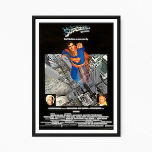 Può includere: Una locandina cinematografica incorniciata di Superman: The Movie, con un'illustrazione centrale di Superman che vola sopra lo skyline di una città. Il testo recita Superman The Movie, You'll believe a man can fly, con cast e crediti.