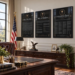 May include: Three framed black posters featuring gold text and emblems, titled The Declaration, The Bill of Rights, and The Constitution of the United States of America, displayed on a wall above a dark wooden desk with a lamp and eagle statue.