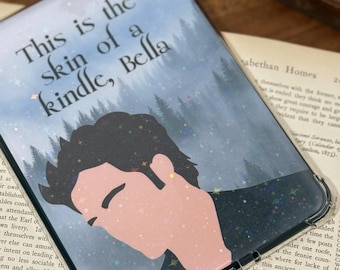May include: Clear Kindle case with a design featuring a silhouette of a person and the text "This is the skin of a kindle, Bella." The case has a glittery, starry background and a red apple charm.