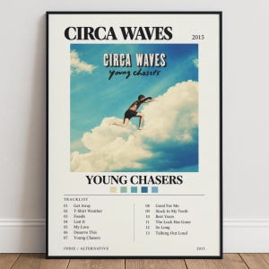 May include: A framed music poster for the Circa Waves album Young Chasers from 2015. The design features a person running on clouds against a blue sky, the band name, album title, a tracklist of thirteen songs, and five small colour swatches.
