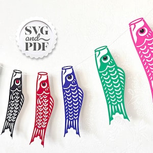 May include: A garland of colorful carp streamers, or koinobori, in various colors including pink, green, red, blue, and black. The streamers are strung on a white string, with a white circle that says "SVG and PDF".