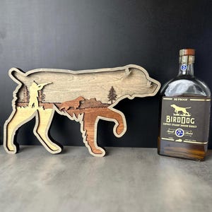 Escultura de madera en capas de un Spaniel bretón, arte de perro de caza de aves de montaña.