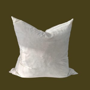 May include: A white pillow with a smooth, slightly textured surface. The pillow is rectangular and has a simple, classic design.