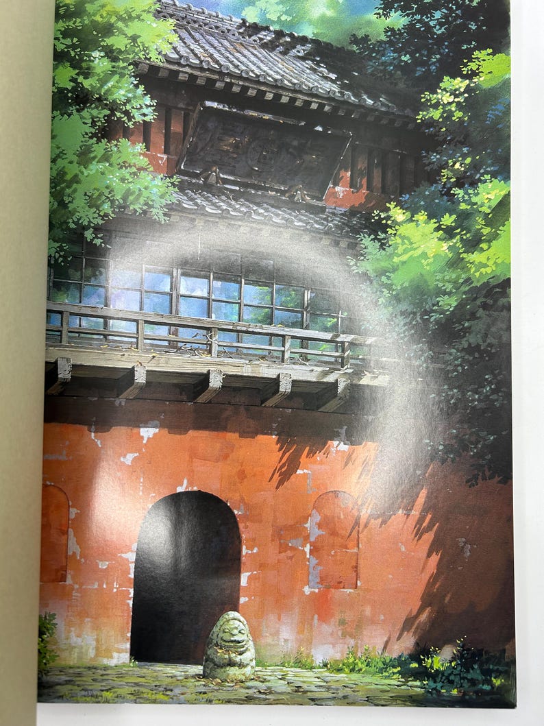 May include: An illustration of a traditional Japanese building with a red-orange wall and a dark roof. Lush green foliage surrounds the structure, with a stone statue in the foreground. The building has a large arched entrance.