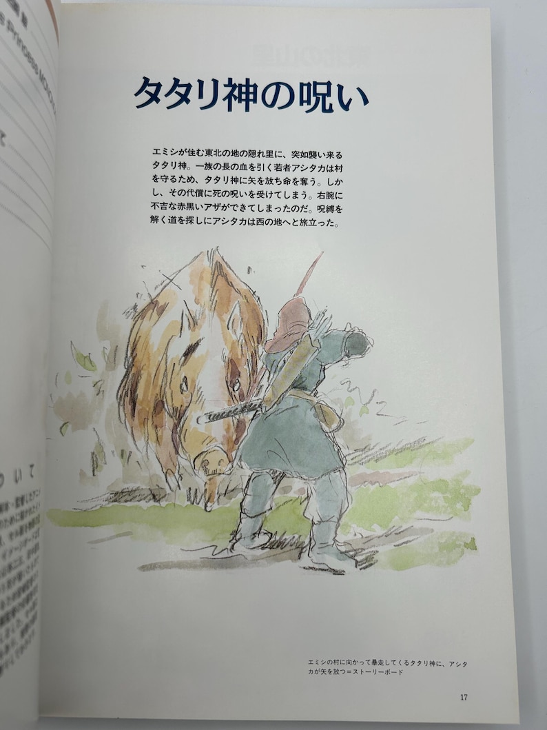 May include: A page from a book featuring a watercolor illustration of a person in a green tunic aiming a bow at a large, brown, wild boar-like creature. The text at the top reads "タタリ神の呪い" followed by Japanese paragraphs describing the scene.