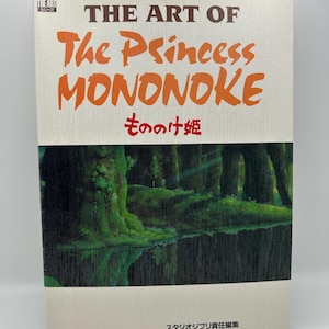 May include: A hardcover book titled The Art of The Princess Mononoke with a cream-colored cover featuring the title in brown and orange text, Japanese characters, and a dark green forest illustration reflected in a body of water at the bottom.