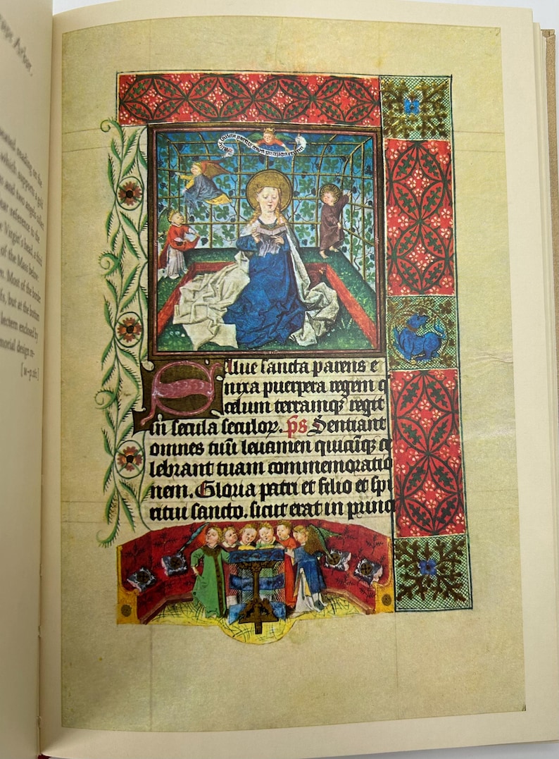 May include: A detailed illuminated manuscript page featuring a central illustration of a woman in a blue gown with a gold halo. The page is adorned with intricate borders in red, green, and gold, and includes Latin text.