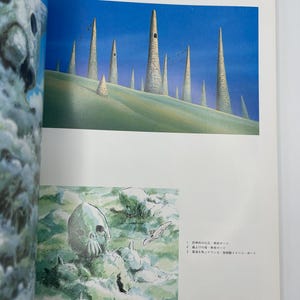 May include: A page from "The Art of Nausica&auml;" featuring two illustrations. The top image depicts tall, cylindrical structures on a green landscape under a blue sky. The bottom image shows a skull-like structure in a misty environment.
