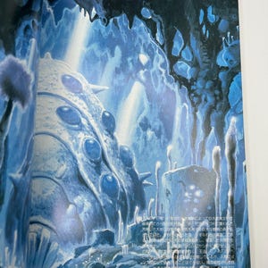 May include: An illustration of a blue and white fantasy landscape with cave-like structures and a large, textured, egg-shaped object. The scene is lit with a cool, ethereal glow, suggesting an underwater or otherworldly environment. The image has a detailed, artistic style.