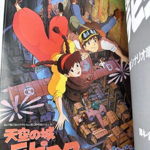 May include: A vibrant illustration from the animated film "Castle in the Sky" featuring characters in flight over a city. The artwork showcases a detailed cityscape with a red airship and Japanese text. The color palette includes shades of red, yellow, and blue.