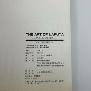 May include: A book titled "THE ART OF LAPUTA" with Japanese text. The cover is white with black text. The book includes details such as the publisher, edition, and printing information.