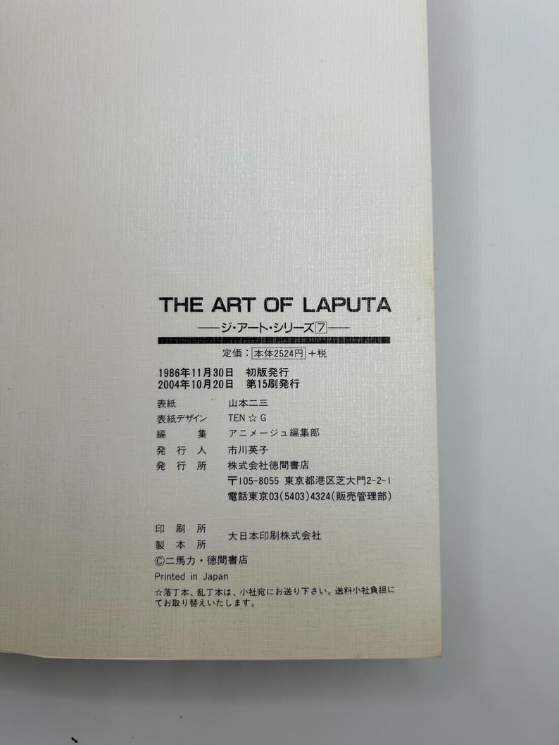 May include: A book titled "THE ART OF LAPUTA" with Japanese text. The cover is white with black text. The book includes details such as the publisher, edition, and printing information.