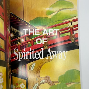 May include: A book cover featuring the title "THE ART OF Spirited Away" in white text. The cover art depicts a red bridge with black accents, green foliage, and a gold background. The book is open.