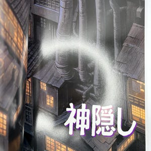 May include: Illustration of a cityscape with industrial pipes and buildings. The image features the Japanese text "Spirited Away" in a stylized font, overlaid on the scene. The buildings have lit windows.