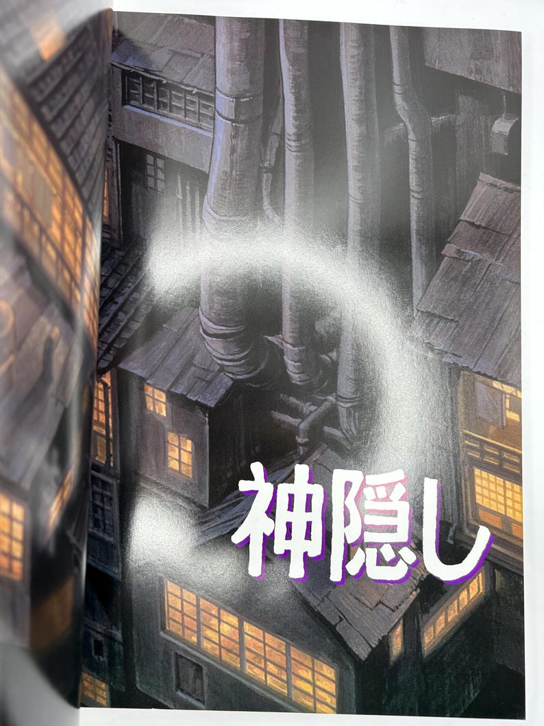 May include: Illustration of a cityscape with industrial pipes and buildings. The image features the Japanese text "Spirited Away" in a stylized font, overlaid on the scene. The buildings have lit windows.