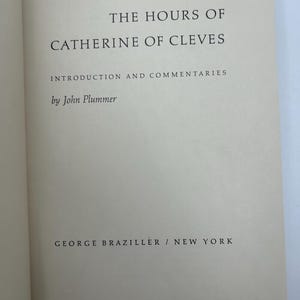 May include: Open book with the title "THE HOURS OF CATHERINE OF CLEVES" in black text. The author's name, John Plummer, and the publisher, George Braziller, are also visible. The book's pages are a light beige color.