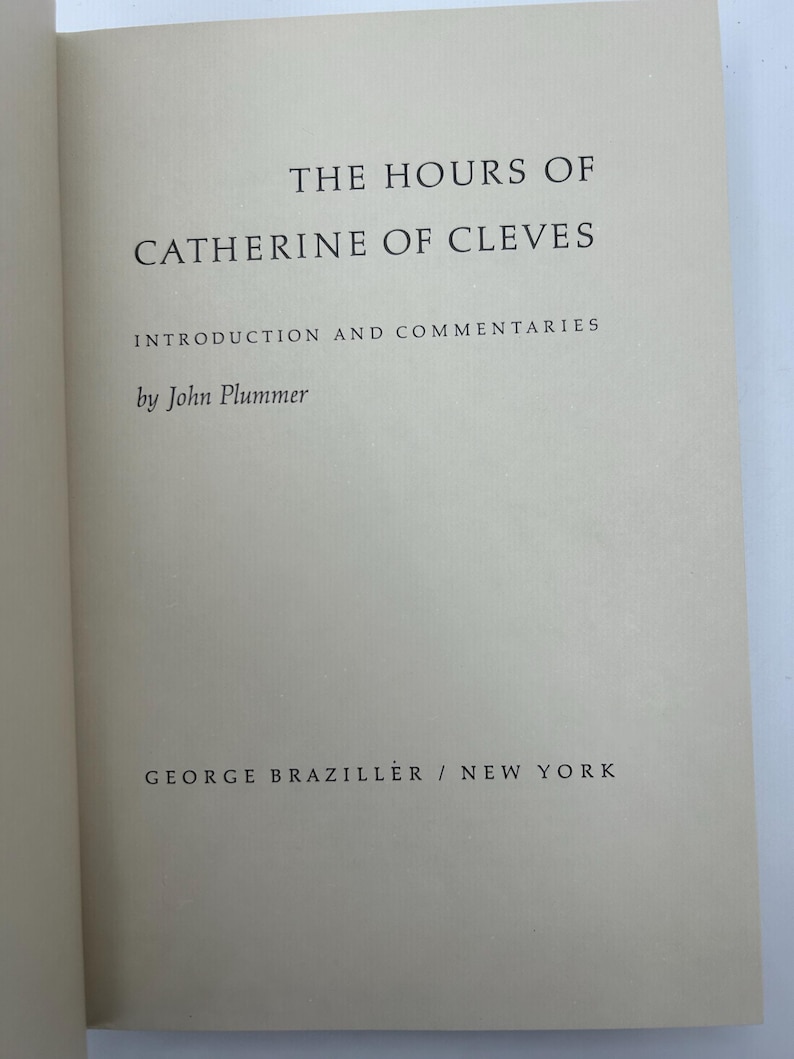 May include: Open book with the title "THE HOURS OF CATHERINE OF CLEVES" in black text. The author's name, John Plummer, and the publisher, George Braziller, are also visible. The book's pages are a light beige color.