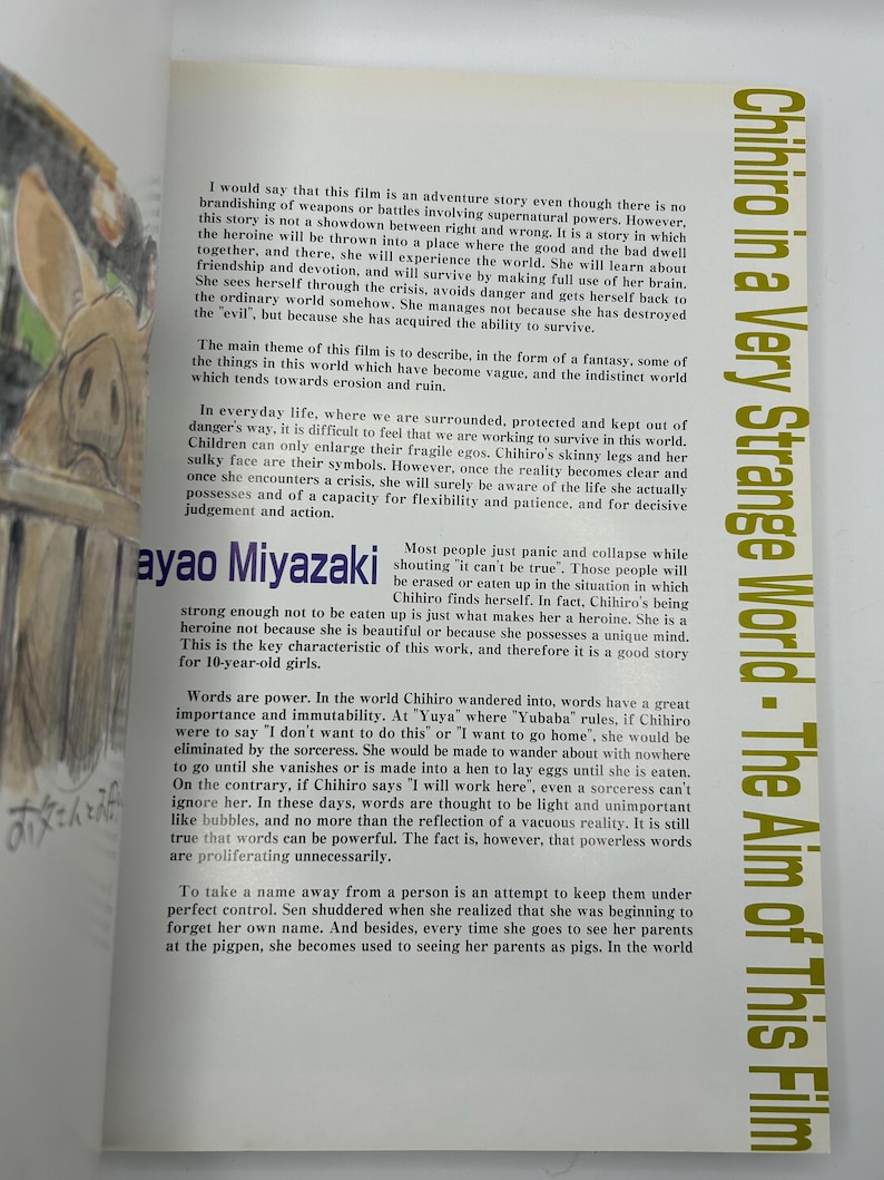May include: An open book with text in English and Japanese. The title "Chihiro in a Very Strange World - The Aim of This Film" is visible. The text discusses the film's themes, characters, and the power of words.