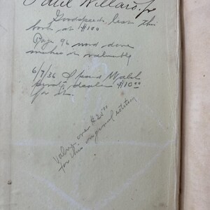 May include: Open book page with handwritten text in black ink. The text includes a name, a price, and other notes. The page is aged with a light tan color. The book appears to be an older edition.