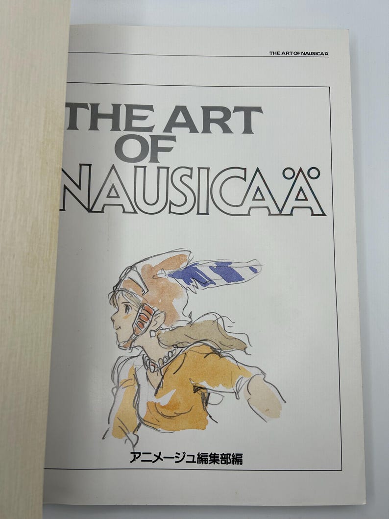 May include: A book titled "THE ART OF NAUSICA&Auml;" with a drawing of a character in a helmet and yellow clothing. The book's title is in large, bold, black letters. The text "THE ART OF NAUSICA&Auml;" is at the top of the page.