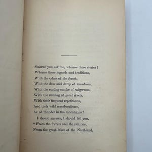 May include: Open book pages with printed text. The text begins with the question, "SHOULD you ask me, whence these stories?" and continues with a poem about legends, traditions, forests, rivers, and the Northland.