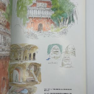 May include: A page from an art book featuring sketches of architectural designs. The top sketch depicts a red building with a tiled roof, surrounded by green foliage. Below are additional sketches of buildings and creatures. Japanese text is present.