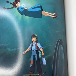 May include: Illustration from an animated film featuring two characters. A woman in a blue dress floats in a bright light. Below, a young man stands on a wooden platform, holding a container. The background is a dark blue.