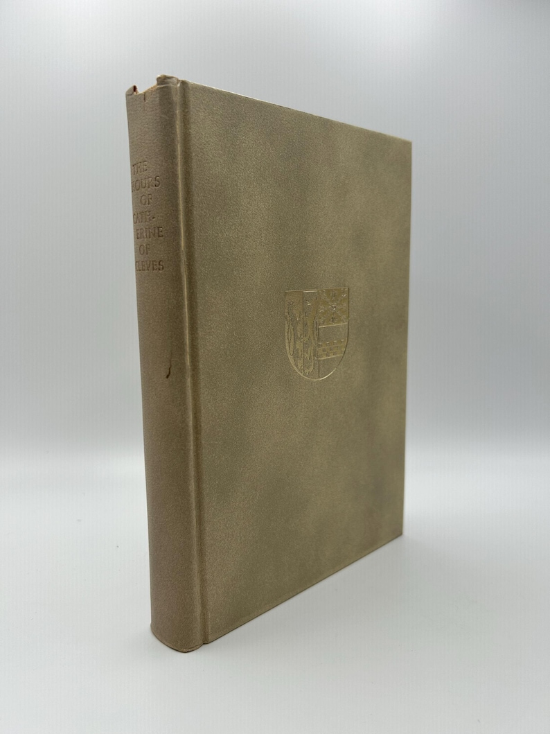 May include: A hardcover book with a tan cover and embossed text and emblem. The book's spine displays the title "THE SOUPS OF EARTH-ERGEVE OF LEVES". A gold emblem is centered on the front cover.