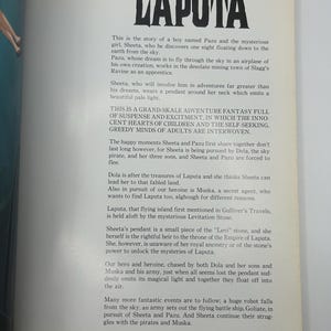 May include: A page from a book with the title "LAPUTA" in large, bold black letters. The text describes a fantasy adventure story about a boy and a girl, with themes of adventure, mystery, and a flying island.