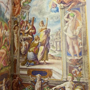 May include: A detailed illustration from a book, featuring a classical painting with figures in various poses. The artwork showcases a vibrant colour palette with yellows, blues, and greens. The scene includes architectural elements and figures in classical attire.
