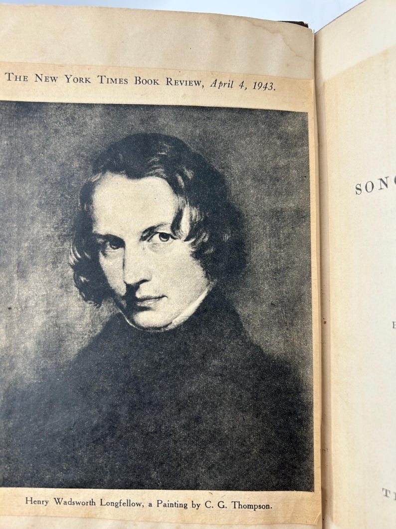May include: A black and white portrait of Henry Wadsworth Longfellow, a painting by C. G. Thompson, featured in The New York Times Book Review, April 4, 1943. The portrait shows a man with dark hair and a dark coat.