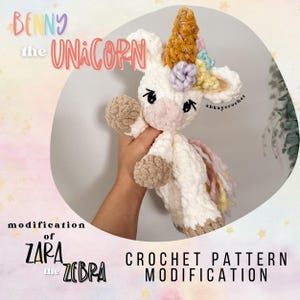 Puede incluir: Unicornio de ganchillo hecho a mano, con cuerpo color crema, pezuñas y manos color beige, y un cuerno dorado. El unicornio tiene un hocico rosa, ojos negros y una melena colorida. El texto en la imagen dice "Benny the Unicorn" y "Crochet Pattern Modification".