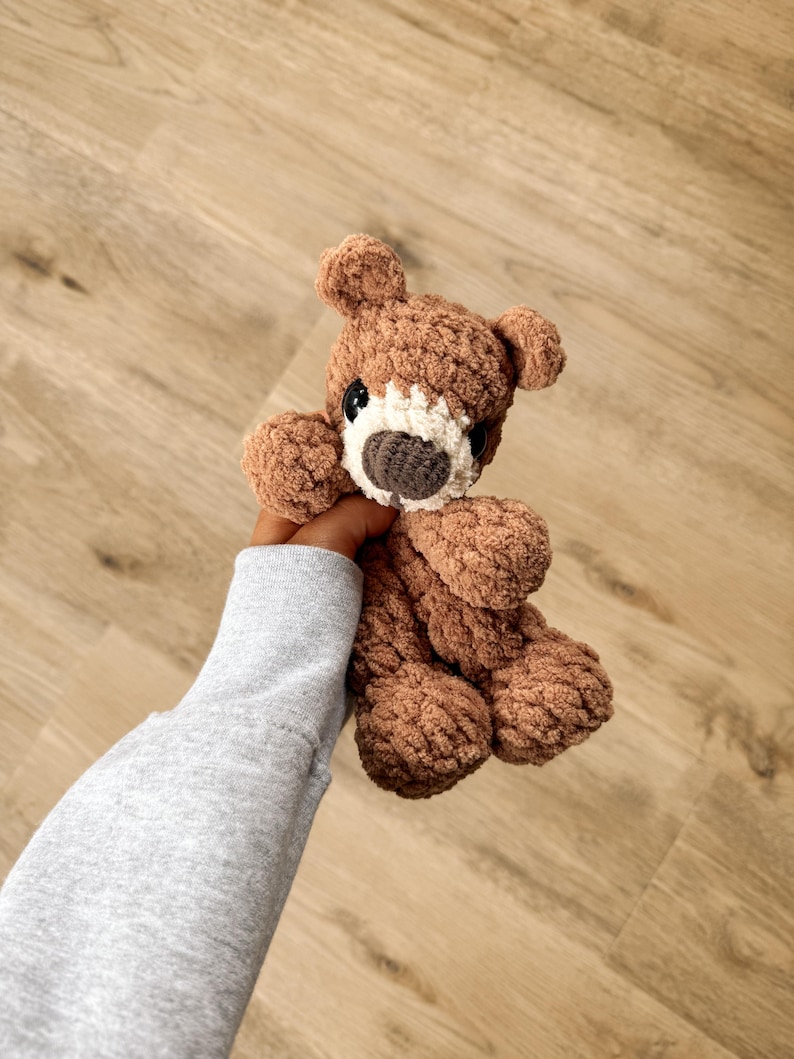 Peut inclure: Un ours en peluche marron fait &agrave; la main avec un aspect pelucheux textur&eacute;. L'ours a un museau blanc, des yeux fonc&eacute;s et un nez brun fonc&eacute;. L'ours mesure environ 20 cm de haut.
