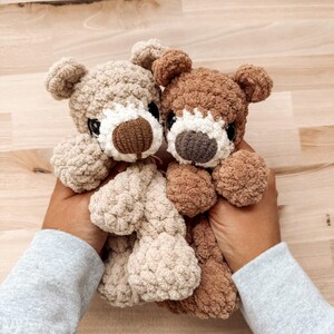 Peut inclure: Deux ours en peluche crochet&eacute;s &agrave; la main. L'un est beige clair, l'autre est marron. Les deux ont des yeux fonc&eacute;s, des museaux blancs et des nez bruns. Les ours sont doux et c&acirc;lins, parfaits pour un jouet d'enfant ou une d&eacute;coration de chambre d'enfant.