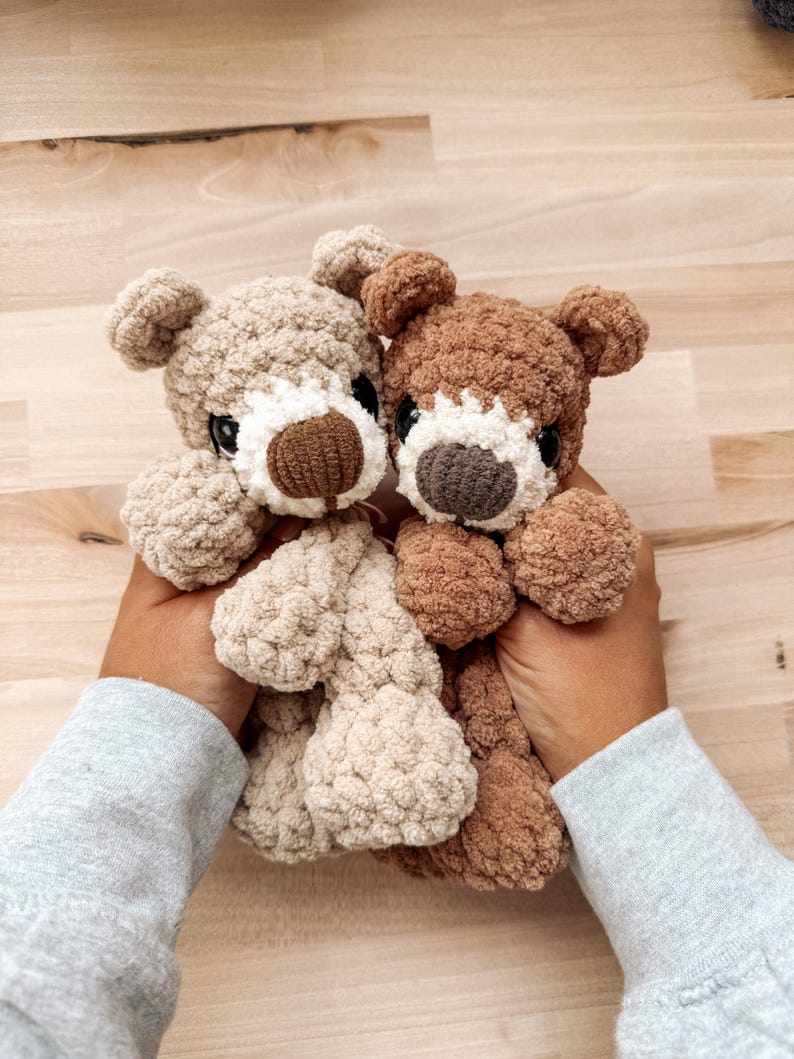 Peut inclure: Deux ours en peluche crochet&eacute;s &agrave; la main. L'un est beige clair, l'autre est marron. Les deux ont des yeux fonc&eacute;s, des museaux blancs et des nez bruns. Les ours sont doux et c&acirc;lins, parfaits pour un jouet d'enfant ou une d&eacute;coration de chambre d'enfant.